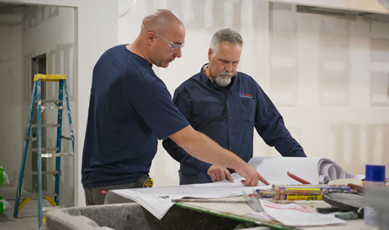 Employees of Armstrong Comfort Solutions looking at blueprints